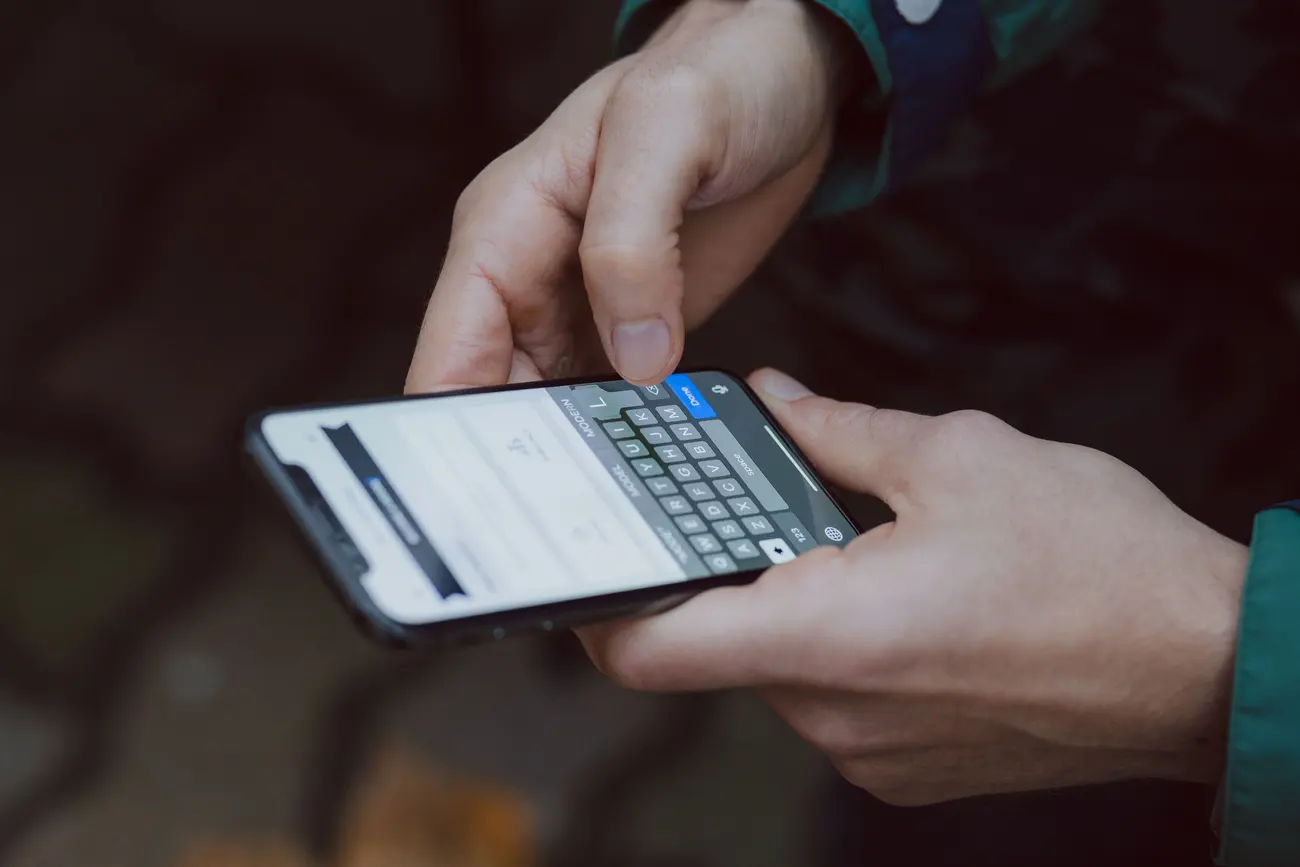 Mãos segurando um celular durante a digitação de uma mensagem de vendas