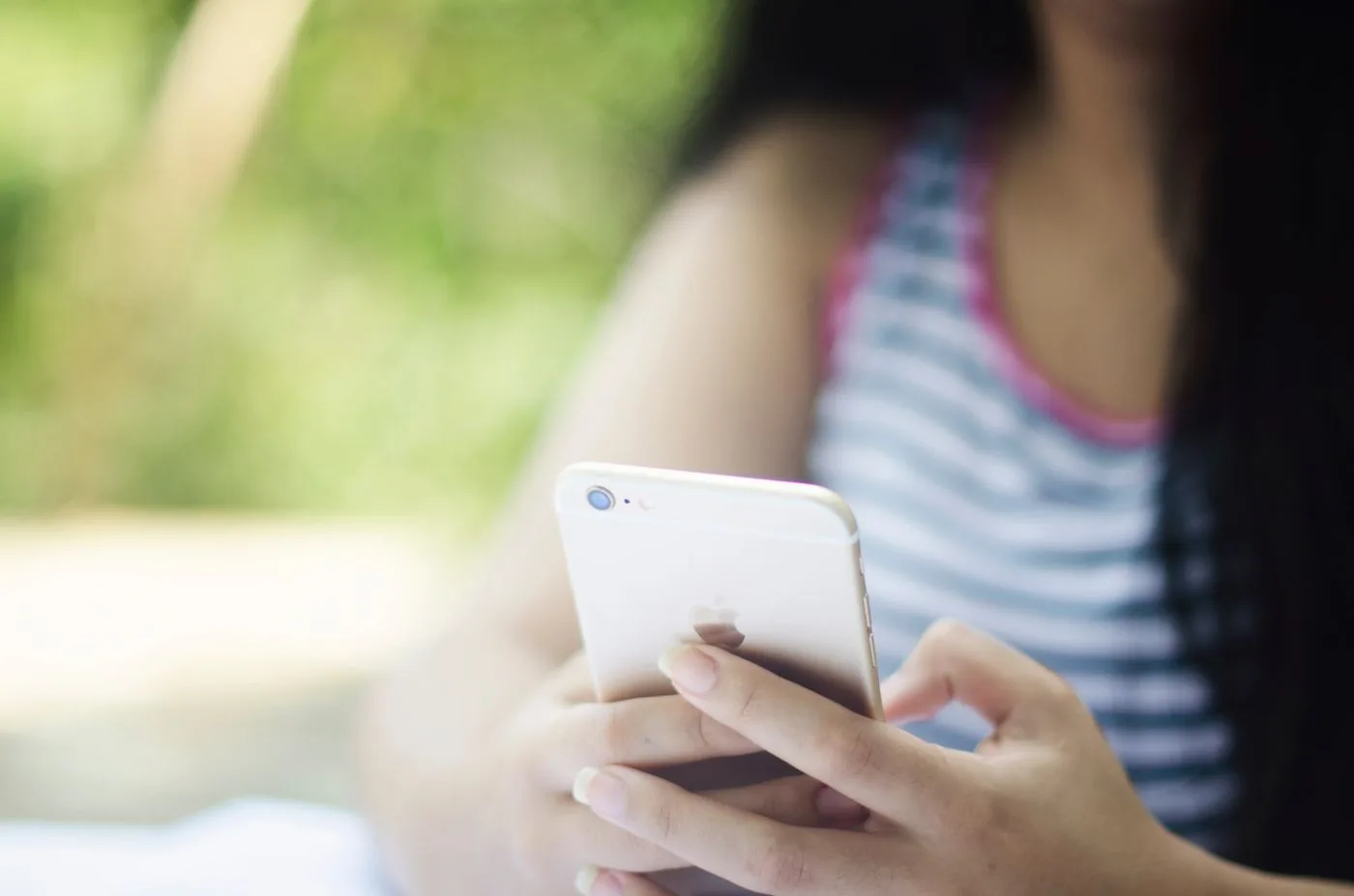 Mulher pesquisando no celular ao ar livre, do jeito que o seu cliente procura um serviço