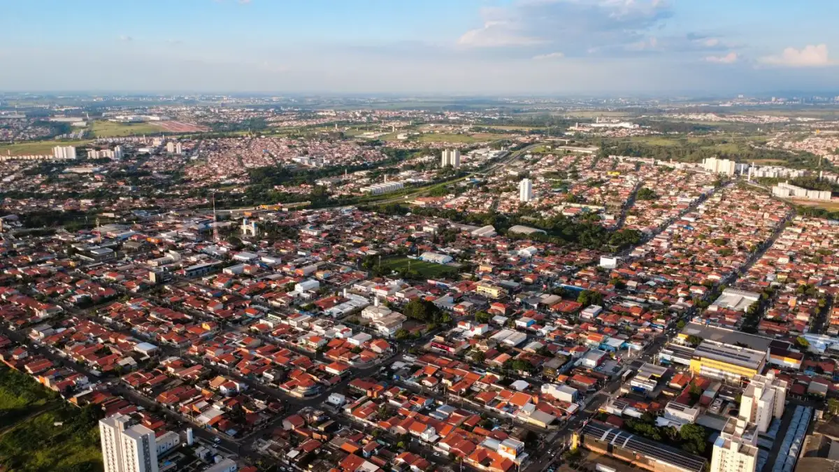 Vista aérea de uma cidade do interior paulista, com casas, prédios e áreas verdes ao redor