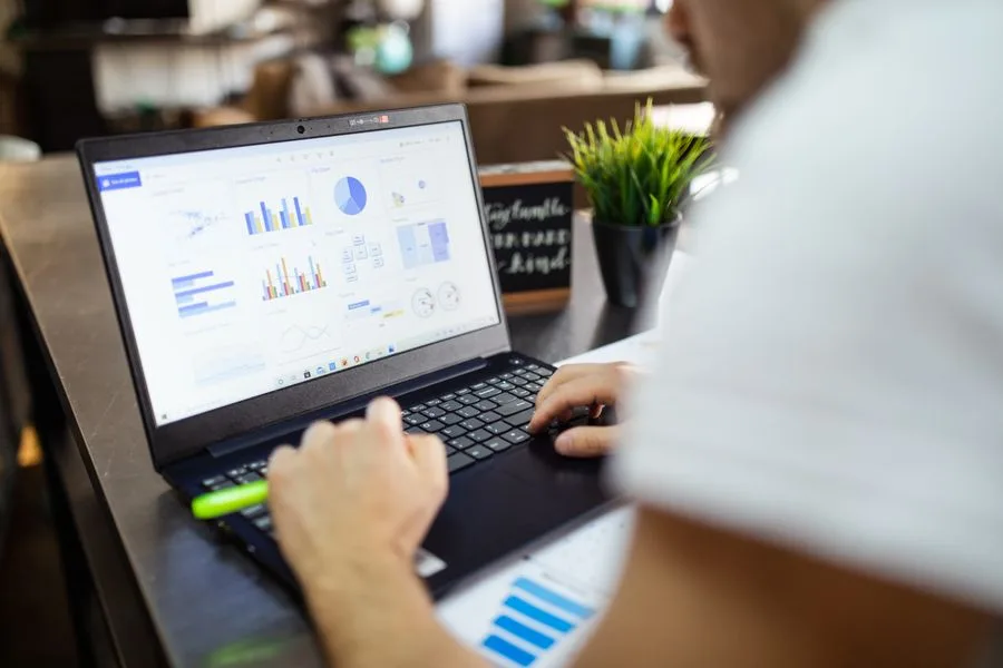 Notebook com painel de gráficos de campanha sobre uma mesa de escritório